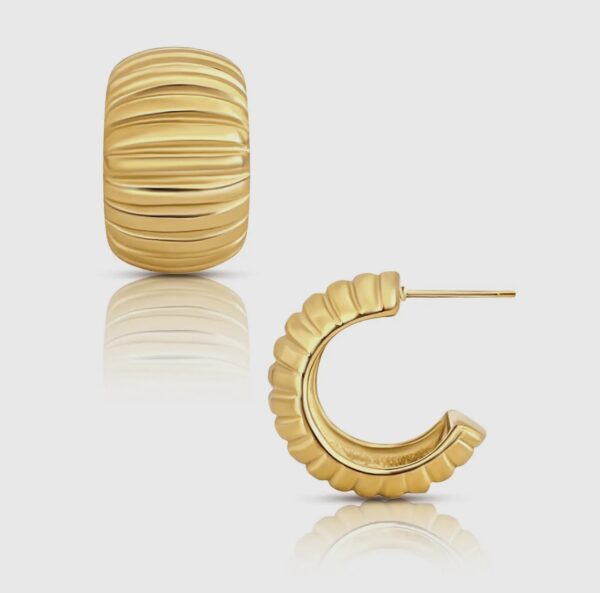 A pair of gold earrings with ridges on them.
