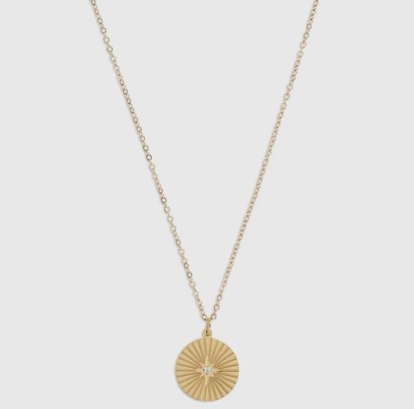 A gold necklace with a compass on it