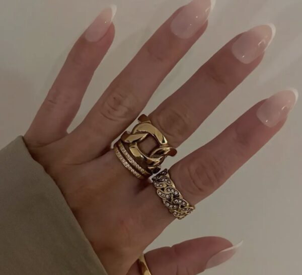 A woman 's hand with two rings on top of it.