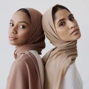 Two women in a tan and brown hijab pose for the camera.