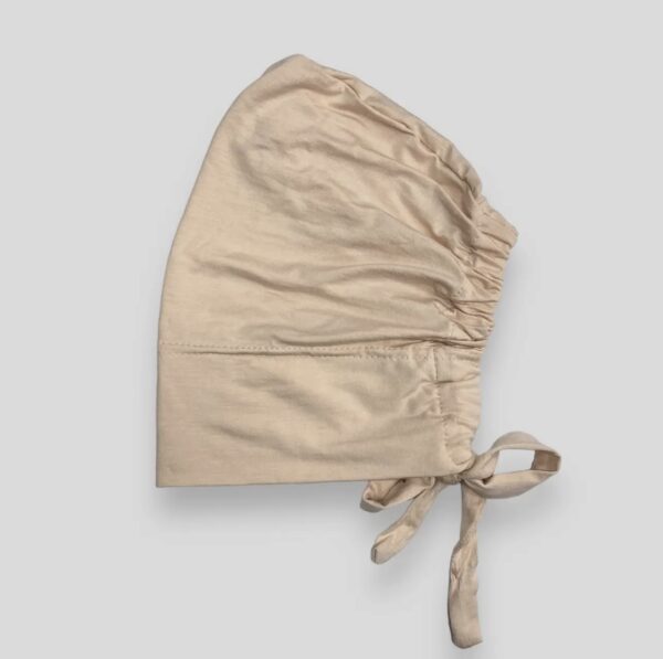 A beige hat with ties on top of it.