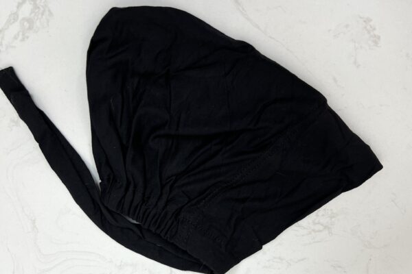 A black cloth is folded up to make a hat.